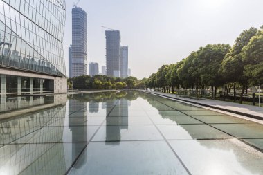 Panoramik siluet ve boş yolu, boş beton zemini olan modern iş binaları.