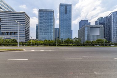Panoramik siluet ve boş yolu, boş beton zemini olan modern iş binaları.