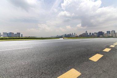 Panoramik siluet ve boş yolu, boş beton zemini olan modern iş binaları.