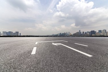 Panoramik siluet ve boş yolu, boş beton zemini olan modern iş binaları.