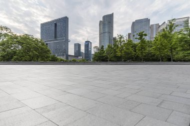Panoramik siluet ve boş yolu, boş beton zemini olan modern iş binaları.