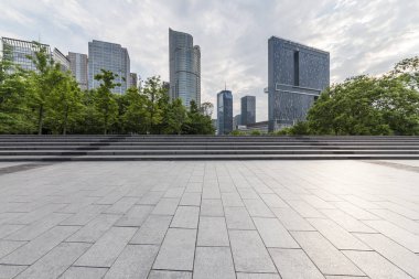 Panoramik siluet ve boş yolu, boş beton zemini olan modern iş binaları.