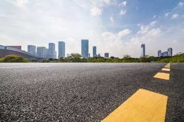 Panoramik siluet ve boş yolu, boş beton zemini olan modern iş binaları.