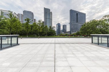 Panoramik siluet ve boş yolu, boş beton zemini olan modern iş binaları.