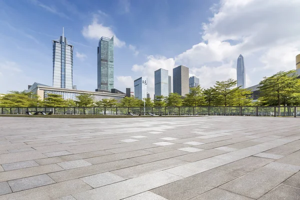 Panoramik siluet ve boş yolu, boş beton zemini olan modern iş binaları.