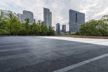 Panoramik siluet ve boş yolu, boş beton zemini olan modern iş binaları.
