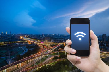 El akıllı telefon ve şehir arka planda internet WiFi ağ bağlantısı iletişim teknolojisini kullanarak