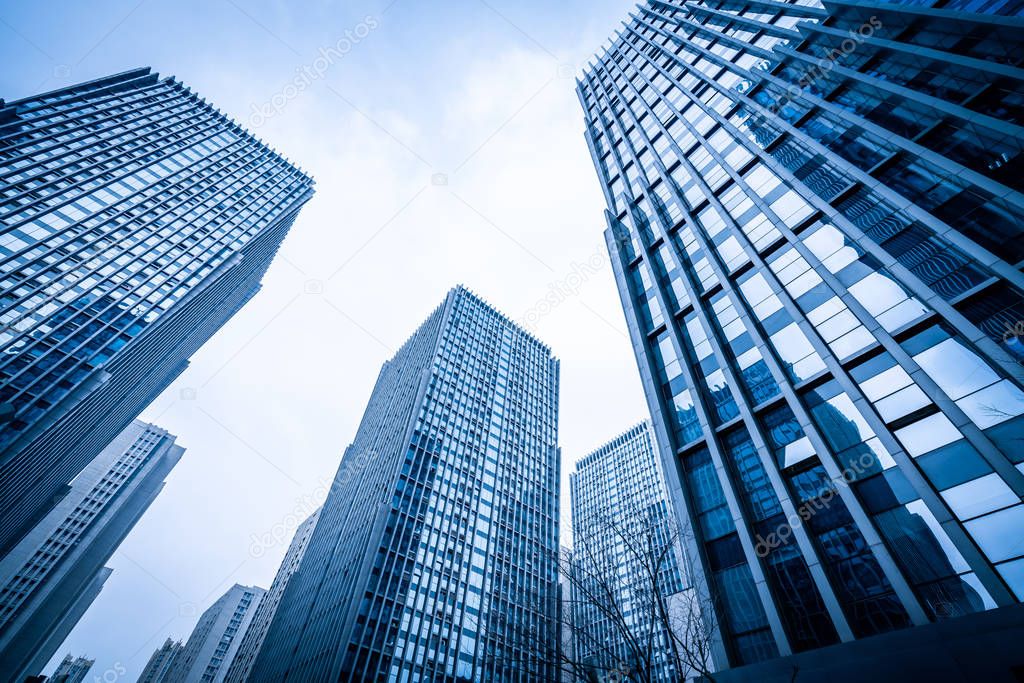 Bottom view of modern skyscrapers in business district against b