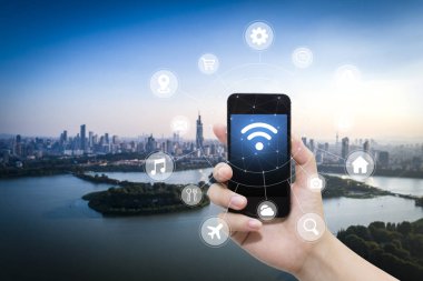El akıllı telefon ve şehir arka planda internet WiFi ağ bağlantısı iletişim teknolojisini kullanarak