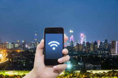 El akıllı telefon ve şehir arka planda internet WiFi ağ bağlantısı iletişim teknolojisini kullanarak