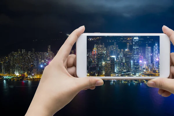 Businessman hand holding empty screen smart phone with city back