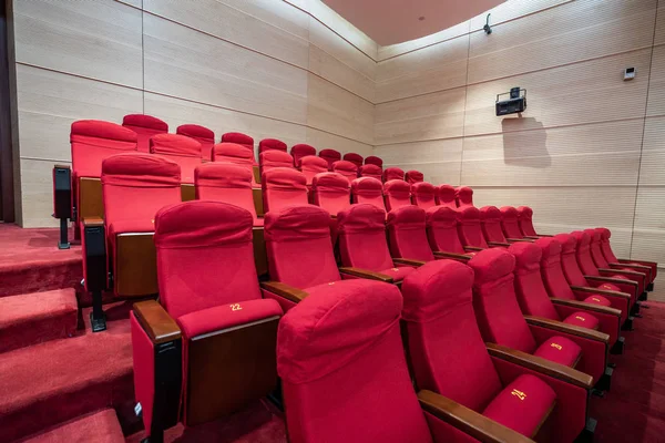 Fileiras de assentos vermelhos dentro de uma sala de cinema — Fotografia de Stock
