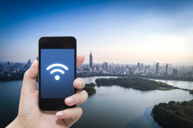 El akıllı telefon ve şehir arka planda internet WiFi ağ bağlantısı iletişim teknolojisini kullanarak