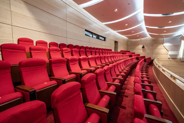 Fileiras de assentos vermelhos dentro de uma sala de cinema — Fotografia de Stock