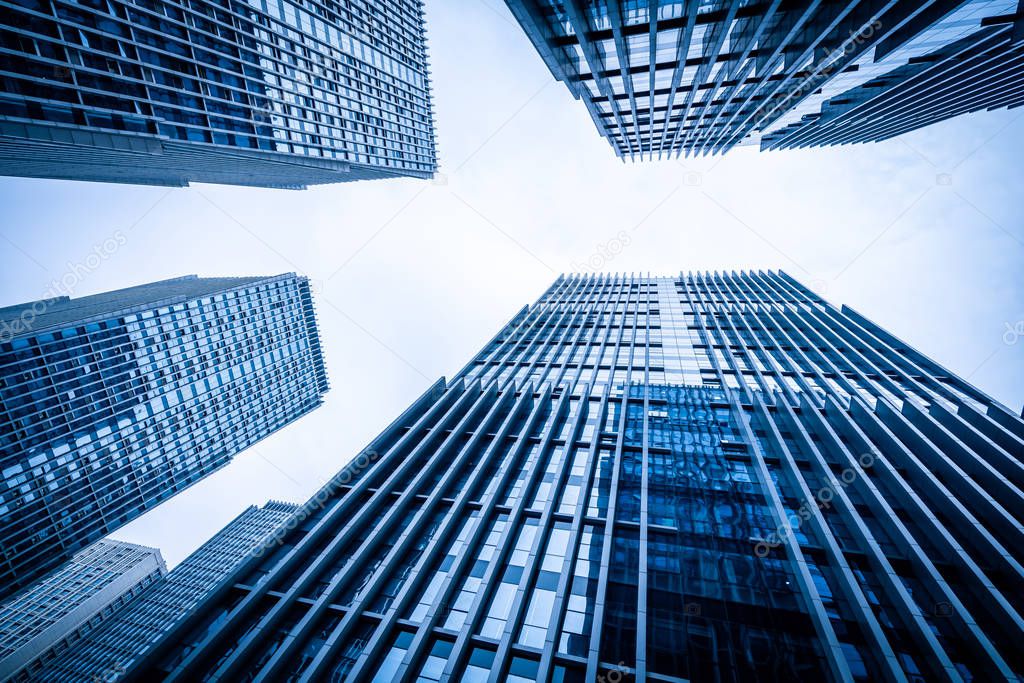 Bottom view of modern skyscrapers in business district against b