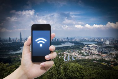 El akıllı telefon ve şehir arka planda internet WiFi ağ bağlantısı iletişim teknolojisini kullanarak