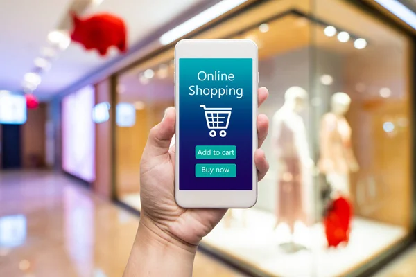 Smart phone online shopping in woman hand. Shopping center in ba