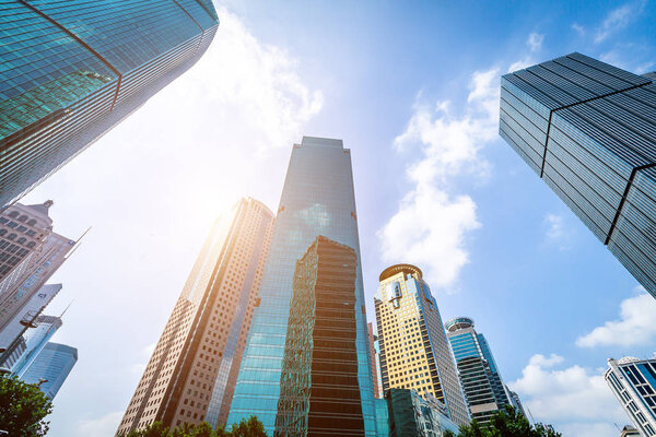 Bottom view of modern skyscrapers in business district against b