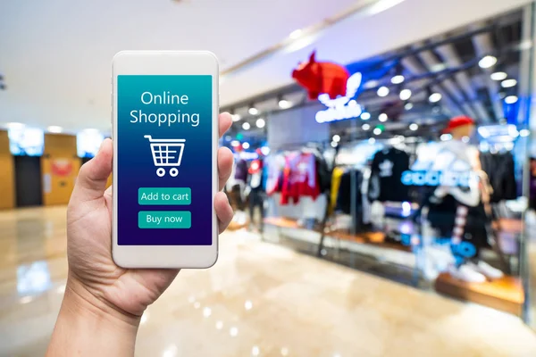 Teléfono inteligente compras en línea en la mano de la mujer. Centro comercial en ba — Foto de Stock