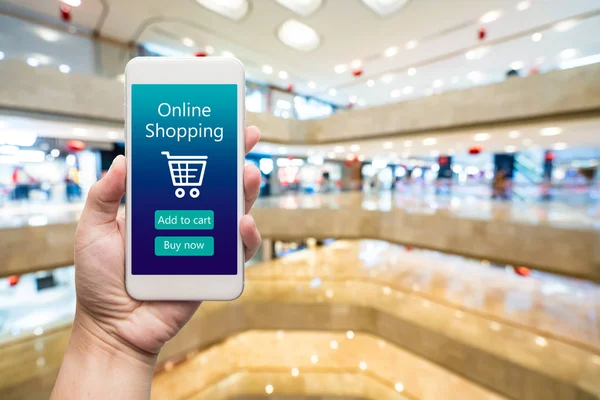 Smart phone online shopping in woman hand. Shopping center in ba