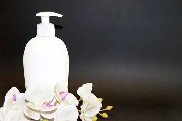 Белая Косметическая Бутылка Белый Цветок Орхидеи Черном Фоне — стоковое фото