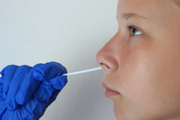 the doctor takes a test for coronavirus from the girl\'s mouth.