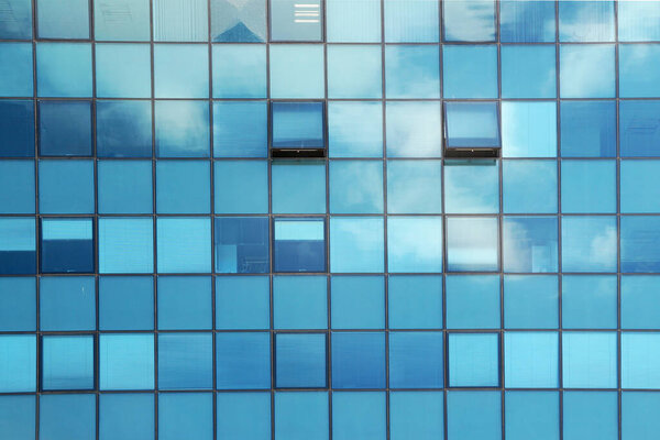 Clouds reflected in the glass facade of a skyscraper close up