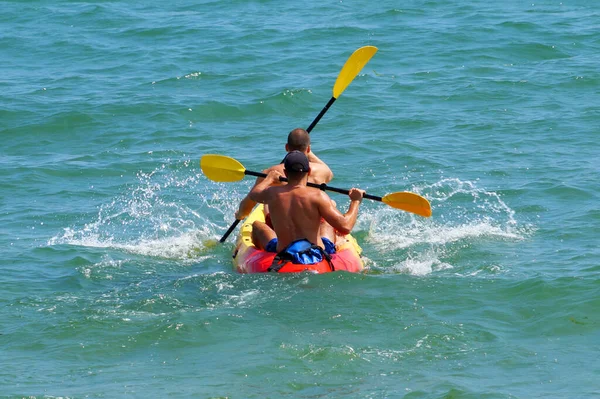 两个年轻人乘皮划艇在海里航行 后视镜 — 图库照片