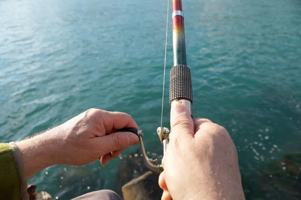 Αρσενικό Χέρι Συστροφή Περιστρεφόμενο Κύλινδρο Στη Θάλασσα Αλιείας Close — Φωτογραφία Αρχείου