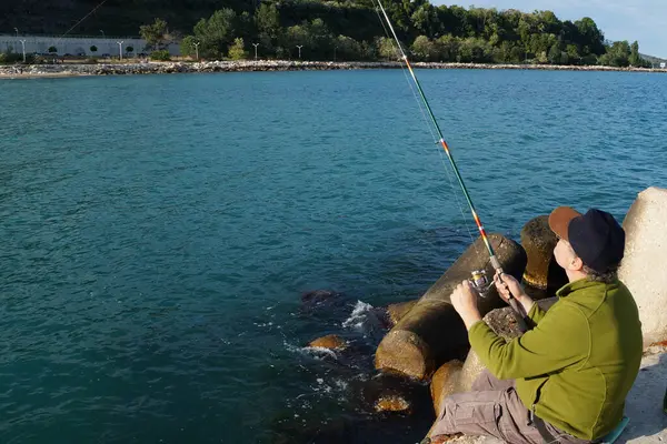 Homem Senta Cais Peixes Girando Pesca Marítima — Fotografia de Stock