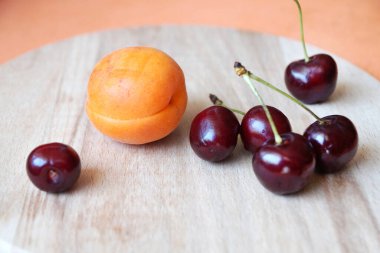 Kayısı ve kirazlar ahşap tepside yakın çekimde.