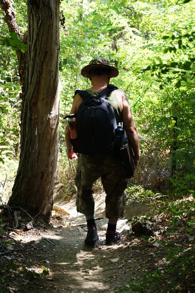 バックパックを持った男が森の小道を歩いて — ストック写真