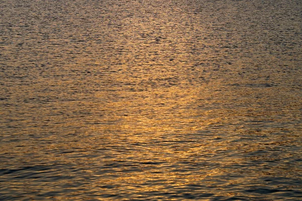 Batan güneş karanlık deniz suyuna yansıyor..