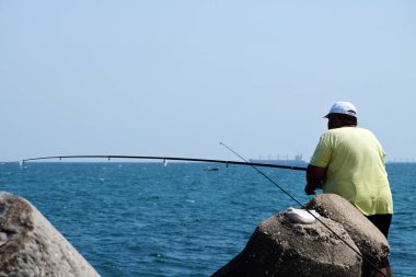 Varna, Bulgaristan - 19 Temmuz 2020: Denizde oltayla balık tutan şişman adam