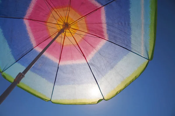 Ήλιος Λάμπει Μέσα Από Μια Πολύχρωμη Ομπρέλα Παραλίας Θέα Από — Φωτογραφία Αρχείου