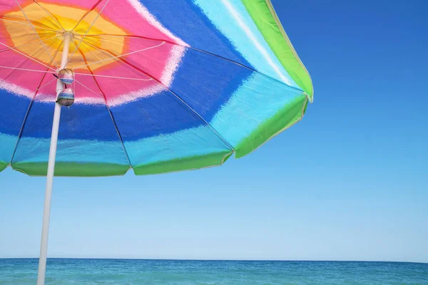 海の地平線と澄んだ空に対するビーチの傘とパレオとサングラスコピースペース — ストック写真