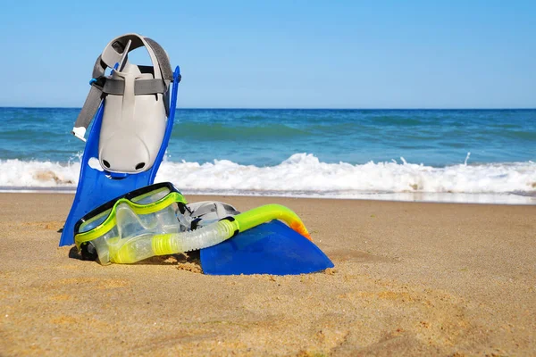 海と澄んだ空を背景に砂の上を泳ぐためのフリッパーとマスク スペースをコピー — ストック写真
