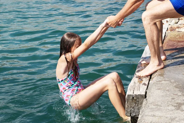 Man Helps Girl Climb Pier Sea — Stock Photo, Image