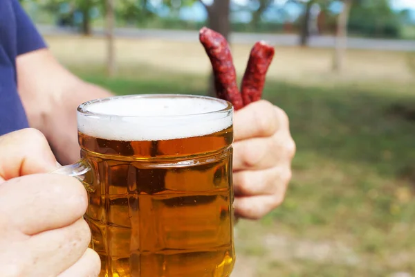 Glas Mok Met Bier Worsten Hand Van Een Man Achtergrond — Stockfoto