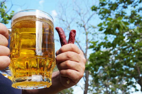 Glas Mok Met Bier Worsten Hand Van Een Man Achtergrond — Stockfoto