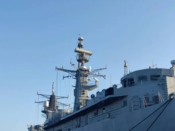Radarlar açık güneşli gökyüzüne karşı büyük ve modern bir savaş gemisinin tepesinde.