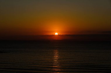 Beach, Karadeniz'den Mamaia, Romanya ile altın portakal gökyüzü, kumları ve mavi berrak su, gündoğumu.