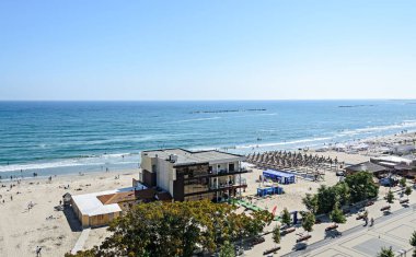 Mamaia, Romanya - 15 Eylül 2017: Beach, Karadeniz'e golden sands, Güneş şemsiyesi, şezlong, mavi berrak su, barlar ve oteller.