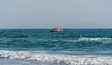 MAMAIA, ROMANIA - SEPTEMBER 15, 2017: Boat near the Beach of Black Sea from Mamaia, Romania, blue clear water. clipart