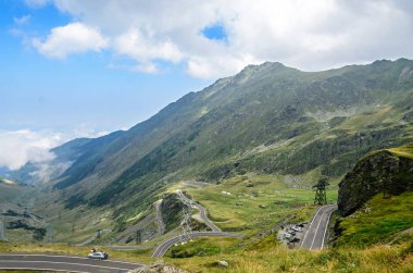 Transfagarasan yolun Fagaras Dağları, yeşil çim ve kayalar, Karpatlar bulutlarda doruklarına.