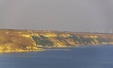 Yeşil Trakya kayalıklarla sarı toprak, Karadeniz'in mavi açık suya yakın rüzgar çiftlikleri.