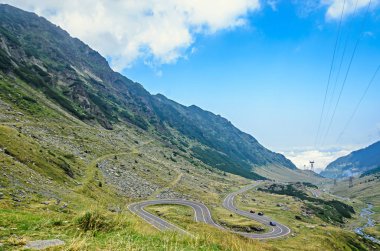 Transfagarasan yolun Fagaras Dağları, yeşil çim ve kayalar, Karpatlar bulutlarda doruklarına.