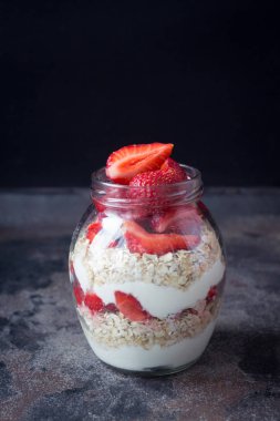 Tomurcukları ve karanlık bir arka plan üzerinde bir kavanoza pembe bir gül yaprakları