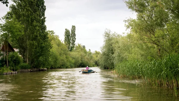 Bela paisagem fluvial com um pequeno barco de pesca que vai ao longo do rio — Fotografia de Stock