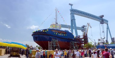 Descent of the new tugboat to the water at the shipyard. clipart